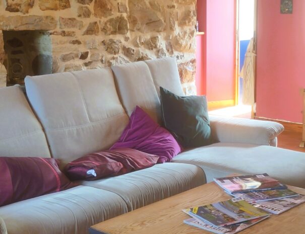 The guest lounge is separate from the owner's main house and is therefore dedicated to the guests. It adjoins the dining room and opens directly onto the terrace. Against the beautiful stone wall, there is a comfortable sofa, an industrial-style coffee table, magazines, books, and tourist information.